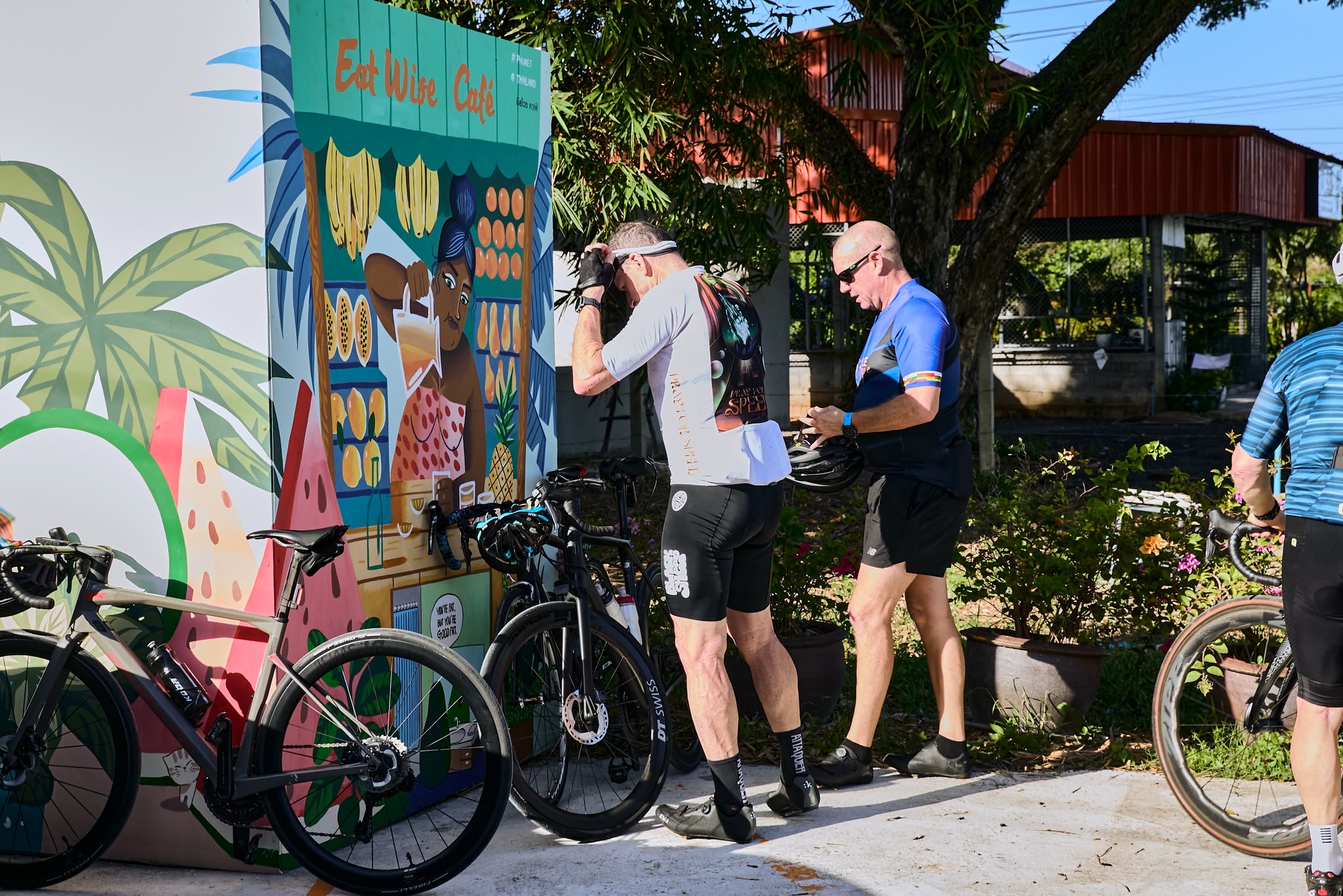 Cyclists parking beside the EatWise Café mural