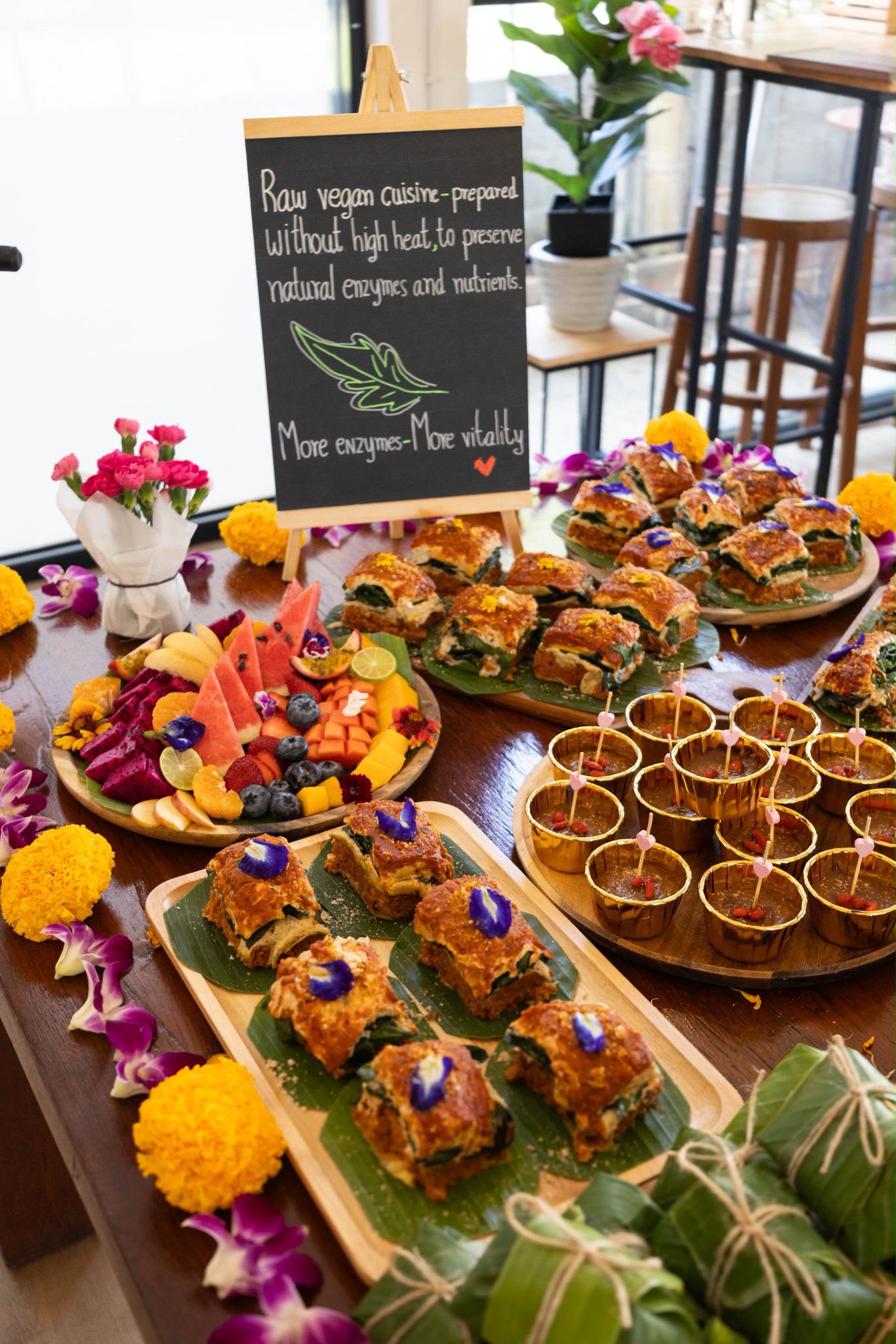 Raw vegan catering spread with sandwich bites, fruit platter and chocolate mousse cups