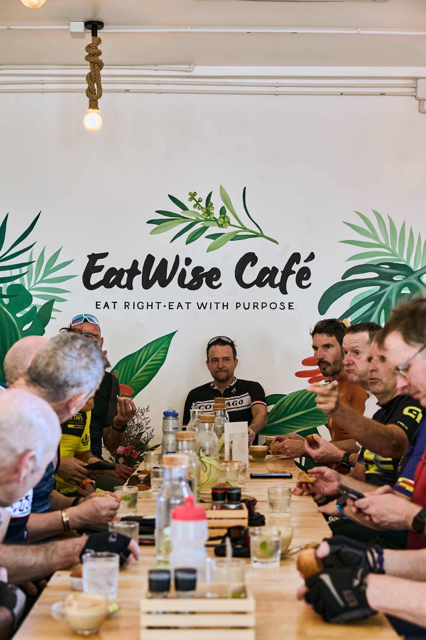 Large group gathered around a long table at EatWise Café